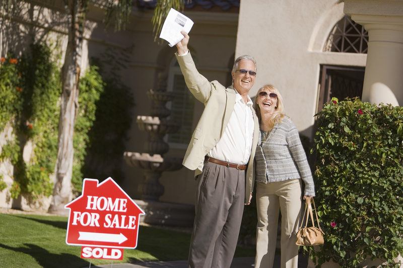 Happy Couple Standing In Front Of Sold House in Indiana