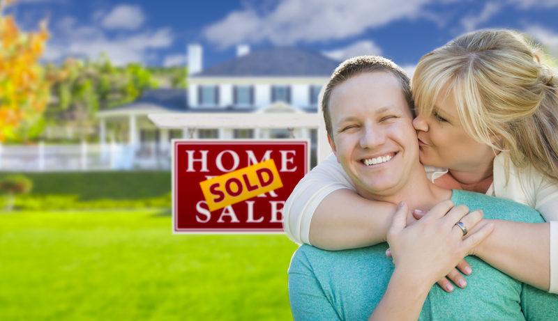Selling Your House Fast Minnesota Couple Kissing In Front of Sold Real Estate Sign and House