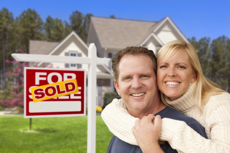 Dallas Couple in Front of Sold Real Estate Sign and House