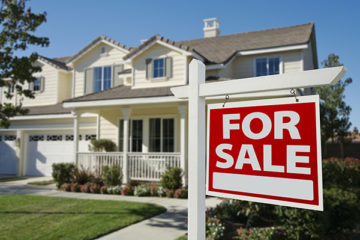 Home for sale sign in front of house