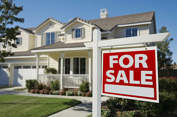 Home for sale sign in front of house