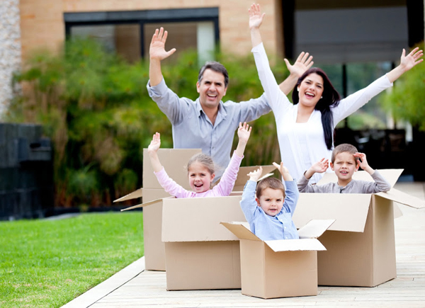 Fun family waving from inside moving boxes