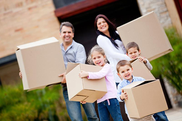 Young family carrying moving boxes after selling house