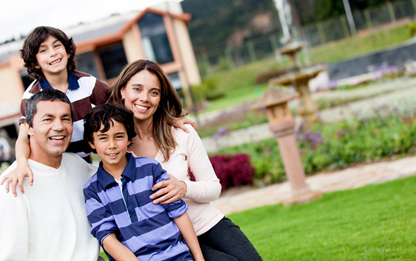 Mother and son smiling while standing in front of their beautiful home