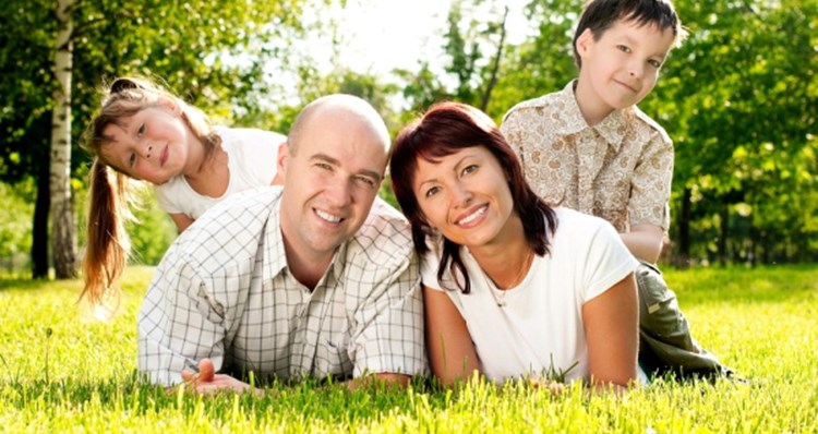 Mature couple laying in the grass of their house's garden in Pittsburgh