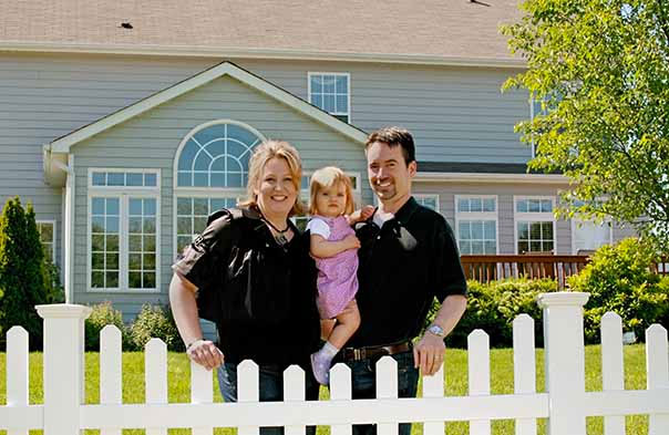 Homeowners standing in front of their home in Detroit.