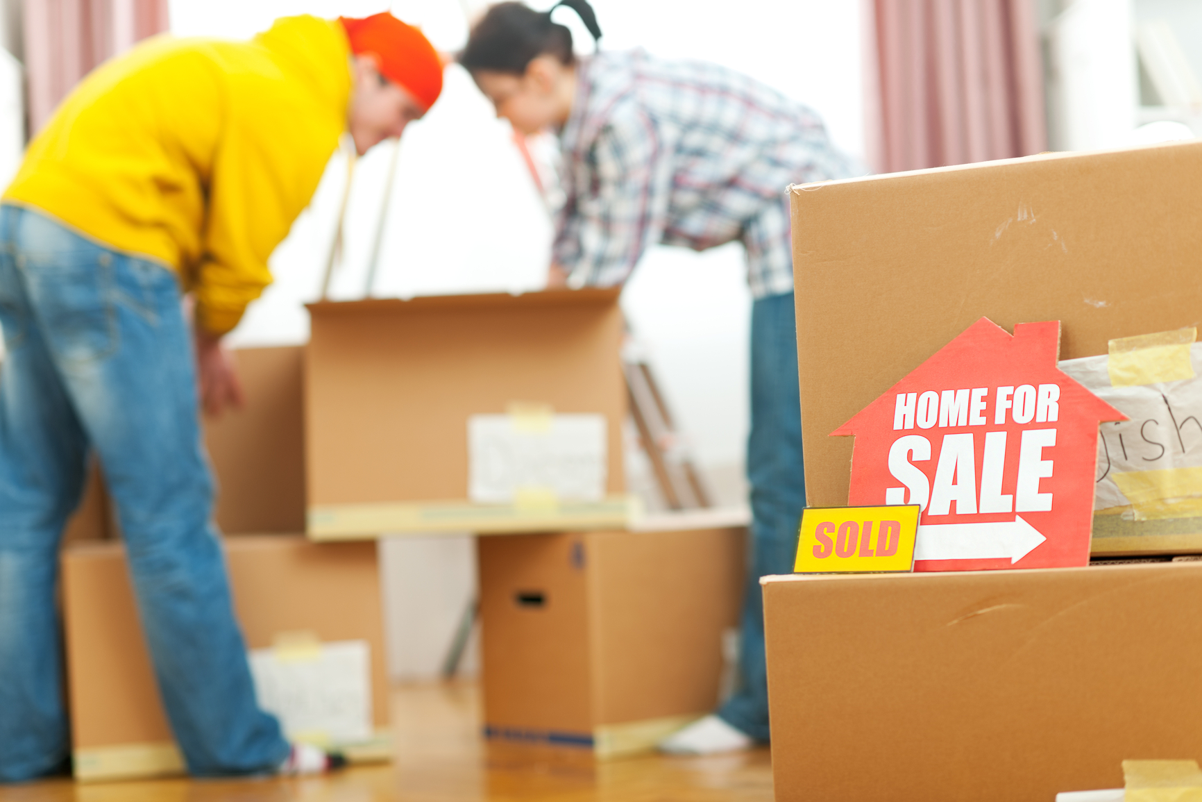 Young couple moving into new house. Unpacking their belongings after finally closing the deal.